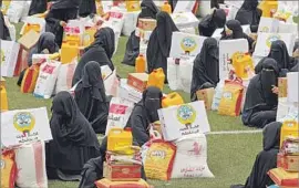  ?? Yahya Arhab European Pressphoto Agency ?? WOMEN in Sana, Yemen, collect donated food rations. Nearly a quarter of Yemen’s 27 million people are “one step away from famine,” a U.N. official said.