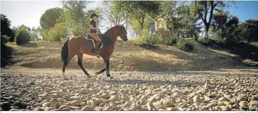  ?? ANTONIO PIZARRO ?? Una mujer monta a caballo por el vado de Quema, ayer.