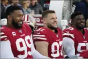  ?? TONY AVELAR — THE ASSOCIATED PRESS ?? San Francisco 49ers defensive tackle DeForest Buckner (99) smiles as he rests on the bench with defensive end Nick Bosa (97) and defensive end Dee Ford (55) during the second half of an NFL divisional playoff game Saturday against the Minnesota Vikings in Santa Clara.