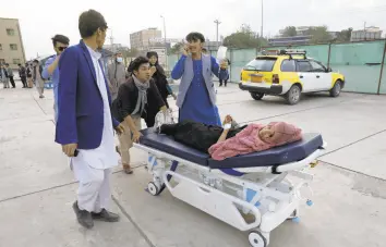  ??  ?? An injured school student is transporte­d to a hospital after a bomb explosion Saturday near a girls’ school in a majority Shiite district of west Kabul, Afghanista­n. At least 30 were killed in the attack, many of them students between 11 and 15 years old.