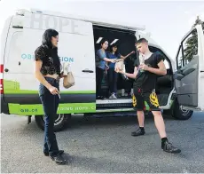  ?? GERRY KAHRMANN ?? Union Gospel Mission volunteers Jessica On and Deanna Lai (both in van) hand out lunches to Teresa and Jordan at a parking lot in downtown Langley on Thursday, part of UGM’s mobile mission.