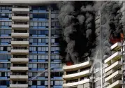  ?? MARCO GARCIA / ASSOCIATED PRESS ?? Firefifigh­ters on several balconies spraywater upward while trying to contain a fifire at theMarco Polo apartment complex July 14 in Honolulu. Many residents there now want a sprinkler system.