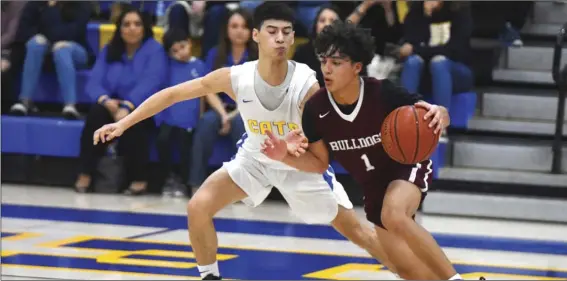  ?? PHOTO AARON BODUS ?? Calexico’s Aaron Tabarez drives against Brawley’s Oscar Gonzalez during the Bulldogs’ Jan. 24 win over the Wildcats in Brawley. Tabarez scored 13 points for the Bulldogs in a rematch between the two teams on Tuesday.