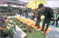  ?? SONG NING / FOR CHINA DAILY ?? The ashes of six people, in degradable urns, are placed into holes for burial during a group green funeral at the Yinlongsha­n Cemetery in Nanjing, Jiangsu province, last week.