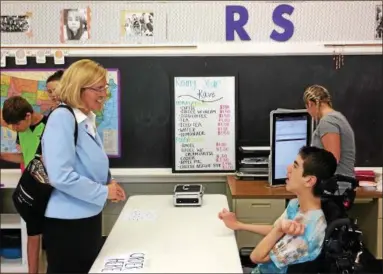  ?? CHAD FELTON — THE NEWS-HERALD ?? Euclid Mayor Kirsten Holzheimer Gail places an order with Thomas DeCarlo at Rising Star Kave inside Rising Star Academy in Euclid on July 12. In its second year, Rising Star’s cafe program allows students with motor disabiliti­es to interact with the...