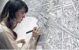  ?? NG HAN GUAN/AP ?? Chinese artist Yang Qian uses dots to recreate an aerial view of the city during the pandemic at her studio in Wuhan, China, which has largely returned to normal.