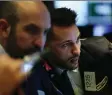  ?? SPENCER PLATT/GETTY IMAGES ?? Traders work on the floor of the New York Stock Exchange.