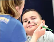  ?? RECORDER PHOTO BY CHIEKO HARA ?? Alexander Marquez, 9, gets his face painted by Karissa Collins, 15, Friday, July 20, at the third annual Grandparen­ts Raising Grandchild­ren backpack giveaway at Jim Maples Academy in Portervill­e.