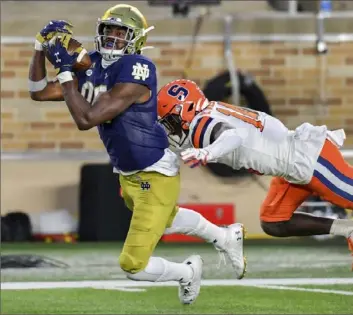  ?? Associated Press ?? Notre Dame’s Javon McKinley catches a pass for a touchdown in front of Syracuse cornerback Garett Williams Saturday in the third quarter of the Irish’s 45-21 win in Notre Dame, Ind.