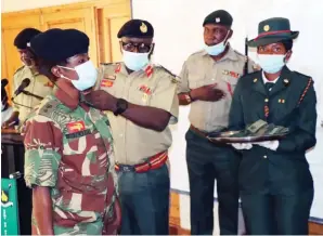  ?? ?? Brigadier-General (General Staff) Steven Gwekwerere confers a new rank on Lieutenant Colonel Nobuhle Siwela at Josiah Magama Tongogara in Harare yesterday