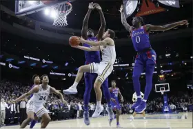  ?? MATT SLOCUM - THE ASSOCIATED PRESS ?? Villanova’s Collin Gillespie, center, goes up for a shot between Kansas’s Udoka Azubuike, left, and Marcus Garrett during the first half of a game, Saturday, Dec. 21, 2019, in Philadelph­ia.