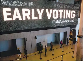  ?? MEGAN VARNER GETTY IMAGES ?? Voters stand in line at the State Farm Arena in Atlanta, Ga., on Dec. 14. Turnout is already high for two Senate runoff races that take place Jan. 5 and have significan­t implicatio­ns for which party controls Congress.