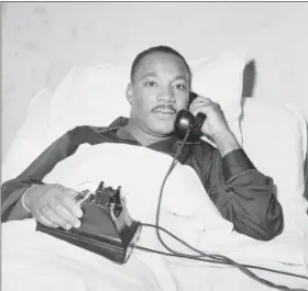  ?? THE ASSOCIATED PRESS FILE ?? Integratio­n leader Dr. Martin Luther King Jr. receives word by phone that he has been awarded the Nobel Peace Prize as he lies in hospital bed in Atlanta, Ga., Oct. 14, 1964, where he went for a checkup.