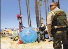  ?? Genaro Molina Los Angeles Times ?? SHERIFF’S DEPUTIES ask tent dwellers in Venice last week if they would accept help from members of the nonprofit St. Joseph Center.