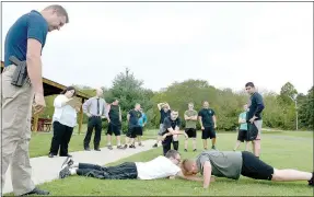  ?? Keith Bryant/The Weekly Vista ?? Lt. Scott Vanatta watches, along with police department staff and applicants, while two applicants work through the push-up portion of the physical test.