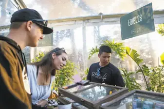  ?? Amy Osborne / Special to The Chronicle 2018 ?? Mitch Smith (left) and Taryn Lee ask Mark Wong about cannabisfr­ee edibles in the Grass Lands area at Outside Lands in 2018. San Francisco indicates sales might be legal this year.