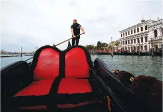  ?? AP PHOTOS/ANTONIO CALANNI ?? Gondoliers President Andrea Balbi sails his gondola at the canal Grande in Venice, Italy, on Wednesday.