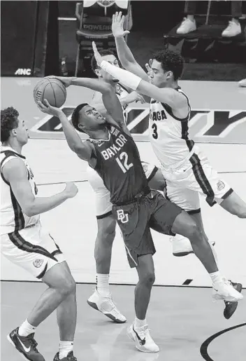  ?? DARRON CUMMINGS AP ?? Baylor guard Jared Butler (12), who scored 22 points Monday and was named most outstandin­g player of the Final Four, shoots between three Gonzaga players during the second half of the championsh­ip game.