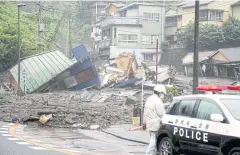  ??  ?? HOMES LOST: Houses damaged by a mudslide are seen following heavy rain at Izusan district in Atami, yesterday.