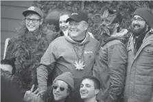  ??  ?? CEO Vic Neufeld, centre, getting into the spirit with Aphria staff Wednesday, says legalizati­on opens up a new growth chapter for the company.