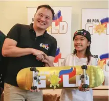  ??  ?? INIABOT ni sports patron at Go For Gold Philippine­s head Jeremy Go ang skateboard sa batang skater na kabilang sa training pool ng asosasyon.