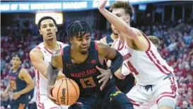  ?? ANDY MANIS/AP ?? Maryland’s Hakim Hart drives between Wisconsin’s Jordan Davis, left, and Carter Gilmore during the first half of Tuesday night’s game in Madison, Wisconsin.