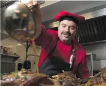  ?? FILES ?? Mahmut Elbasi, chef and owner of Anatolia, sauces some stuffed lamb and rice in the restaurant across from Olympic Plaza.