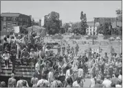  ?? THE ASSOCIATED PRESS ?? National Guardsmen stand ready on the other side of a steel mesh fence erected May 15, 1969, by University of California officials around People's Park in Berkeley, while some of the thousands who marched in protest pass by.