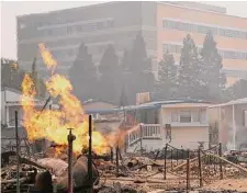  ?? Associated Press file photo ?? Kaiser Permanente’s Santa Rosa Medical Center, background, evacuated 122 patients in 2017 as wildfires surrounded the Northern California hospital. It closed for 17 days.