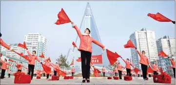  ??  ?? Members of a Socialist Women’s Union propaganda troupe perform a dance and music routine in front of the Ryugyong hotel in Pyongyang. — AFP photos