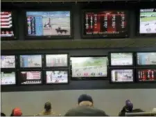  ?? SETH WENIG — THE ASSOCIATED PRESS FILE ?? Men watch horse racing on an array of screens at Monmouth Park Racetrack in Oceanport, N.J. New Jersey Gov. Phil Murphy said Friday his state will have sports betting “sooner rather than later,” but gave himself no timetable to act on a bill to...