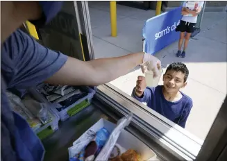  ?? LM OTERO — THE ASSOCIATED PRESS ?? Tiffany Sawczenko hands a drink sample out her food truck window in McKinney, Texas. When the pandemic was declared in March 2020retail­ers worried about the potential spread of the coronaviru­s so they cut off free sampling of everything from food to makeup to toys. Now with vaccinatio­ns rolling out and the threat of COVID-19 easing in the U.S., food vendors and stores are feeling confident enough to revive the tradition.