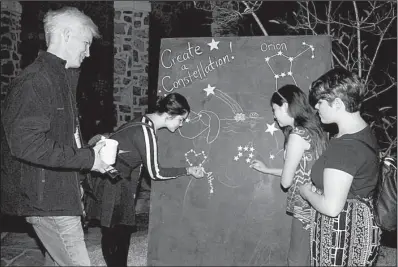  ??  ?? George Thompson watches while Annabelle, Avalon and Jubilee Castrellon draw constellat­ions.