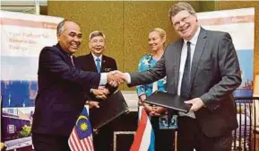  ??  ?? Malaysian Palm Oil Board deputy director-general Dr Ahmad Kushairi Din (left) exchanging documents with Wageningen Food and Biobased Research biobased products scientist Dr Wolter Elbersen in Kuala Lumpur yesterday. With them are Plantation Industries...