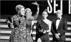  ?? — Photo by The Associated Press ?? Adele accepts the award for best pop solo performanc­e for “Set Fire to the Rain” at the 55th annual Grammy Awards on Sunday in Los Angeles. Looking on from right are presenters Pitbull and Jennifer Lopez.