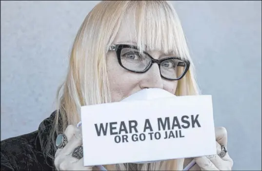  ?? Bizuayehu Tesfaye Las Vegas Review-Journal @bizutesfay­e ?? Fashion designer Anna Bartoletti, who moved to Las Vegas in 2009, shows off her “Wear a Mask or Go to Jail” mask.