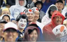  ?? Allen J. Schaben Los Angeles Times ?? FANS OF Team Japan get a kick out of couples shown kissing on the Dodger Stadium video board during WBC semifinal game with U.S.