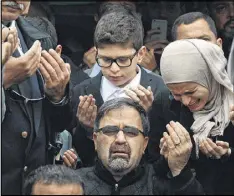  ?? AP ?? Namee Barakat, bottom center, watches as his son Deah Shaddy Barakat is buried Thursday in Wendell, N.C. Deah Barakat, his wife and her sister were killed in a shooting Tuesday. A neighbor has been charged with murder.