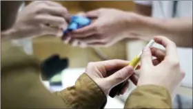  ?? EUGENE HOSHIKO - THE ASSOCIATED PRESS ?? In this Oct. 22 photo, visitors try out pen-like “heat-not-burn” device iQOS at an IQOS store at Ginza in Tokyo. In Japan, Philip Morris opened nine iQOS stores in trendy districts nationwide, offering free WiFi and drinks, to perk consumer interest.