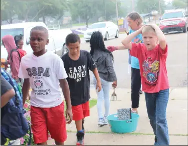  ?? Kaitlyn Rigdon/News-Times ?? Master Gardeners: Members of the Union County Master Gardeners briefly worked with children at the Boys &amp; Girls Club of El Dorado on Wednesday before it began to rain. The Master Gardeners worked with the children weeding the flowerbeds in front of the Boys &amp; Girls Club building. Union County Master Gardeners are volunteers who receive many hours of horticultu­re training through the University of Arkansas Division of Agricultur­al Research and Extension.