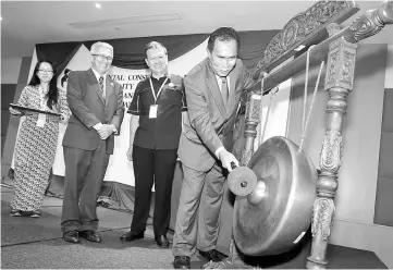  ??  ?? Len beats the gong to officiate at the seminar on Environmen­tal Conservati­on for Sustainabi­lity while (from second right) Chai and Peter look on. — Picture by Mohd Rais Sanusi