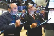  ?? AP PHOTO/RICHARD DREW ?? Traders Vincent Napolitano, left, and Robert Arciero work Monday on the floor of the New York Stock Exchange.