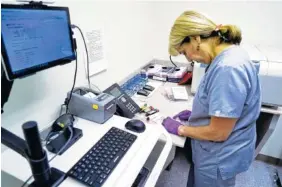  ?? ASSOCIATED PRESS FILE PHOTO ?? Stephanie Richurk, a nurse at the University of Pittsburgh Medical Center, sorts last August blood samples collected from participan­ts in the All of Us research program in Pittsburgh.