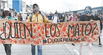  ?? FERNANDO VERGARA/AP PHOTOS ?? Students holding a poster that reads “Who killed them?” in Spanish march on Sept. 21 in Bogota, Colombia.