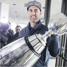  ??  ?? Argonauts quarterbac­k Ricky Ray shows off the Grey Cup on Monday.