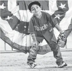  ??  ?? Diamondbac­ks fan Mikey Lujan, 5, of Peoria, waits for fly balls during the team’s annual FanFest at Chase Field in Phoenix on Saturday.