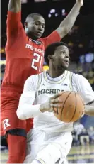  ?? | CARLOS OSORIO/ AP ?? Michigan guard Zavier Simpson looks to pass as Rutgers forward Mamadou Doucoure defends.