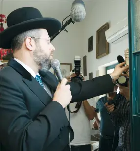  ?? (Noa Grayevsky) ?? CHIEF RABBI David Lau affixes a mezuza on Ronald Lauder’s office.