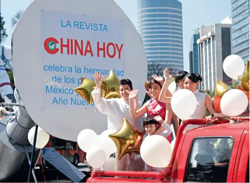  ??  ?? Los amigos mexicanos saludan al público en el vehículo adornado de China Hoy en un desfile realizado en la Ciudad de México.