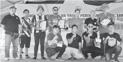  ??  ?? KENANGAN: Zaini (tiga kanan, belakang) bergambar bersama para pemenang dan peserta ‘arm wrestling’ pada Majlis Penutupan Program Business On Truck Peringkat Negeri Sarawak di Medan Niaga Satok di Kuching, semalam.